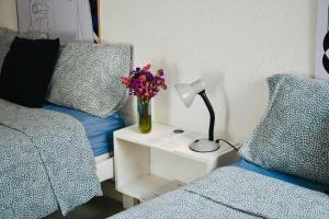 a bedroom with a bed and a table with a lamp and flowers at Casa Nazimova Indigo Room in San Cristóbal de Las Casas +62 photos
