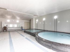 a large swimming pool in a large room at Century Plaza Hotel in Tokushima