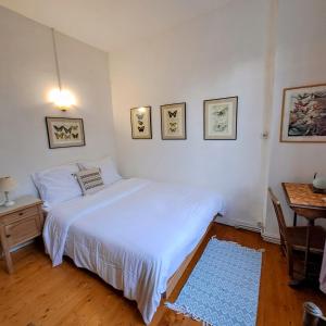 Un dormitorio con una cama blanca y una mesa. en appartement dans la Villa Colibri,, en La Baule 11 fotos más