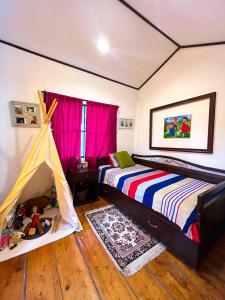 a bedroom with two beds and a play tent at Casa Heidi, Apaneca in Apaneca
