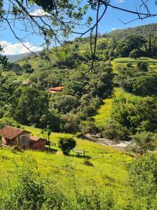 a small house in the middle of a grassy hill at Cheiro de Flor - Gamarra in Baependi