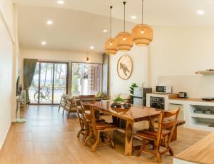 泰孟Turtle Tales-Tahnu,Thaimueang beach,Phang-Nga的配有木桌椅的厨房和餐厅