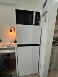 a microwave sitting on top of a refrigerator at SABBATH uzumasa 102 in Kyoto