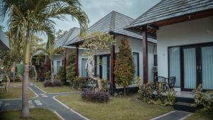 a row of houses with palm trees in front of them at Umahita Lodge Penida in Toyapakeh