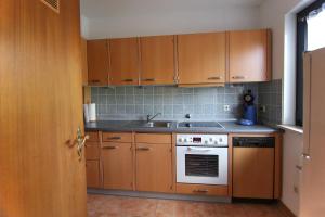 a kitchen with wooden cabinets and a sink at Ferienhaus 43 in Burhave in Burhave