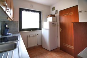 a kitchen with a white refrigerator and a window at Ferienhaus 43 in Burhave in Burhave +16 photos