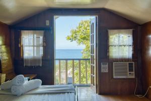 a bedroom with a view of the ocean at Pilar Pilapil Beach House in Malapascua in Daanbantayan