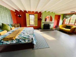 a bedroom with a bed and a couch and a fireplace at Rustic Farmhouse, Curry's Post - SOLAR POWERED in Currys Post