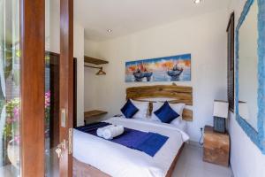 a bedroom with a bed with blue and white pillows at Aveli Villa 5 Bedroom with Pool at Seminyak 5 Mnt To beach by Car in Seminyak +46 photos