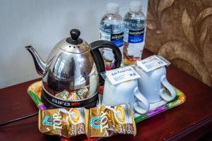 a tea kettle and two bottles of water on a table at Melin Hotel Tanjungpinang in Tanjung Pinang