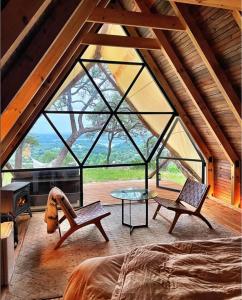 Zimmer mit einem großen Fenster mit einem Tisch und Stühlen in der Unterkunft Talula Mesa Glamping Resort - Austin Hill Country in Marble Falls