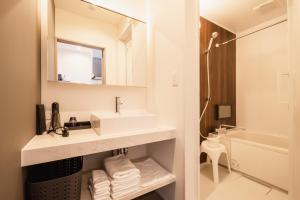 a white bathroom with a sink and a mirror at The Nine States Hotel KARATSU in Karatsu +44 photos