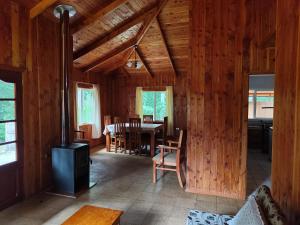 a living room with a table and a stove at Cabaña Leandro Lago Panguipulli in Panguipulli