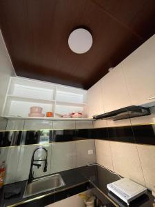 a kitchen with white cabinets and a sink and a light at The Roam Inn - Fast Wifi Connection in Dipolog +20 photos