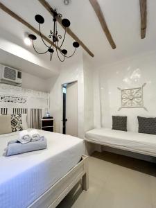 a bedroom with two beds and a chandelier at Lugar Bonito Hotel in Boracay