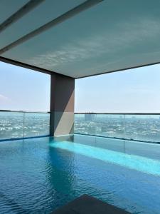 a swimming pool in a building with a view at BTS Bearing 23Fl 68sqm condo with open city view Shared rooftop and gym in Samut Prakan +22 photos