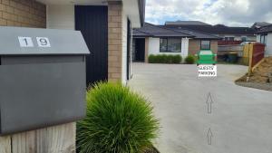 una casa con un cartel que dice aparcamiento para invitados en 19 Arahi Place, Rototuna North -Hamilton NZ, en Hamilton