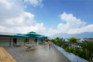 Un patio con mesas, sillas y sombrillas. en m designer hotel, en Dujiangyan