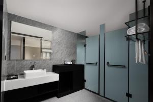 un baño con lavabo y espejo en m designer hotel, en Dujiangyan