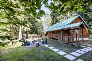 a log cabin with a green roof in a yard at Log Cabin with King Bed and Hot Tub in Ashford