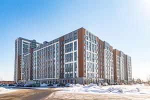 an apartment building with snow in front of it at Красотка на Нурлы Жол in Astana