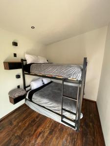 two bunk beds in a room with a wooden floor at Cabañas Corazón del Bosque in Tapalpa