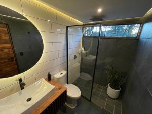 a bathroom with a shower and a toilet and a sink at Cabañas Corazón del Bosque in Tapalpa +71 photos