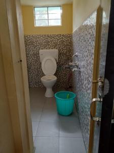 a bathroom with a toilet and a bucket at Pt khongknaw homestay in Mawlynnong
