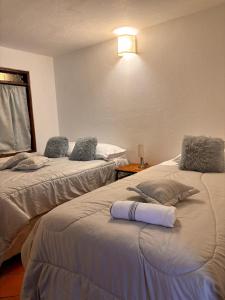 a room with two beds with towels on them at Casa Xiscua in Villa de Leyva
