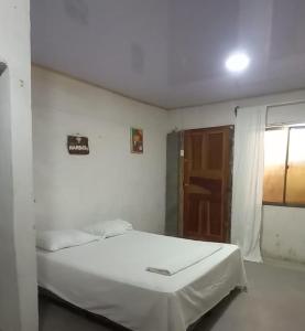 a white bed in a room with a window at Hostal Brisas del Ometepe Habitación 3 in Rivas