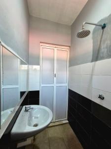 Un baño con lavabo blanco y ducha. en Juwita Homestay Bukit Katil - Free Unifi and 15 Minutes To Town, en Melaka