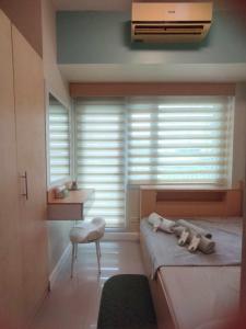 a bedroom with a bed and a desk and a window at Stay at Love Grass in Manila +21 photos
