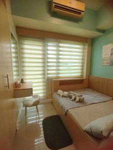 a bedroom with a bed and a window with a fan at Stay at Love Grass in Manila