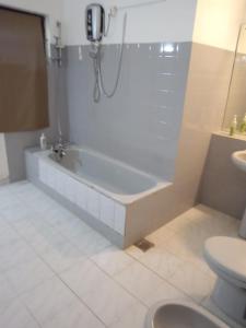 a bathroom with a bath tub and a toilet at Grand Villa Wellawatta in Colombo