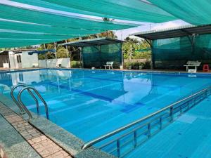 a large blue swimming pool with a blue canopy at Nhà nghỉ Mai Lan in Cái Răng