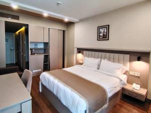 巴统Infinity Tower apartments Batumi的一间带大床的卧室和一间厨房 更多21张照片