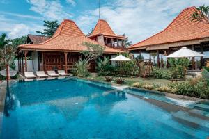 a swimming pool in front of a house at Primavera villa with 7 bedrooms in Krambitan