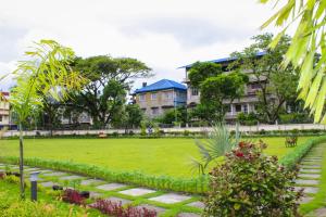 a green park with buildings in the background at Arunachal Bhawan in Tinsukia