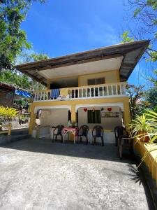 ein Haus mit Stühlen und einem Tisch davor in der Unterkunft Ling Ling Homestay in Apo Island