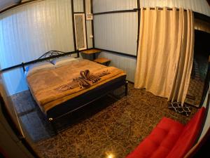 a view of a bedroom with a bed and a couch at PinkHouse in Ban Bang Bao