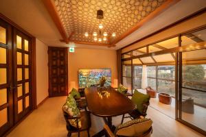 a living room with a wooden table and chairs at 山海温泉別荘Hot Spring Villa in Beppu