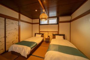 a room with two beds in it with a window at 山海壱 in Beppu +116 photos