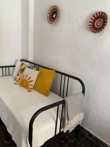 Una cama con almohadas amarillas en una habitación. en Casa Carmen Oliva Townhouse, en Oliva