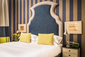 a bedroom with a large white bed with yellow pillows at Vmaison Hotel Messina in Messina