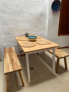 una mesa de madera con dos tazones y dos bancos en Casa Carmen Oliva Townhouse, en Oliva 50 fotos más