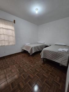 a room with two beds and a wooden floor at Casa Café in San Lucas Tolimán