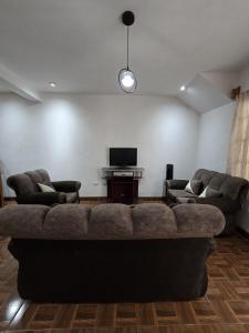 a living room with a couch and a flat screen tv at Casa Café in San Lucas Tolimán