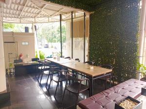 un restaurant avec une table et des chaises dans une salle dans l'établissement Kyrie Hotel, à Surabaya