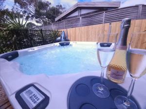 Cape WoolamaiSpacial Rend的热水浴池,配有2杯葡萄酒和温度计