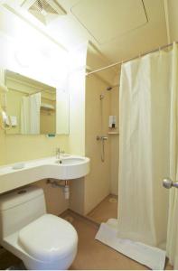 a bathroom with a toilet and a sink and a shower at Jinjiang Inn Qingdao Bus Station in Qingdao